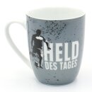 Kaffeebecher / Tasse aus Porzellan, Motiv: Held des Tages. Gr&ouml;&szlig;e H/&Oslash;: 9,8 x 8,2 cm, Fassungsverm&ouml;gen 250 ml, Sp&uuml;lmaschinengeeignet.